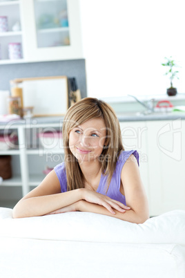 Captivating caucasian woman sitting on a sofa looking to the sid