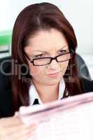 Concentrated young businesswoman reading a newspaper