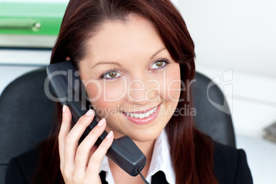 Positive young businesswoman talking on phone