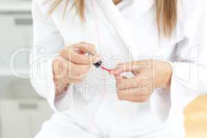 Close-up of a caucasian woman varnishing her fingernail