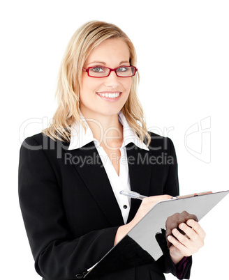 Charming businesswoman writing on a clipboard