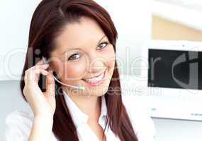 Charming young businesswoman wearing headphones smiling at the c
