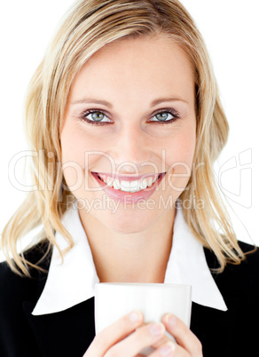 Radiant businesswoman holding a cup smiling at the camera