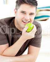 Smiling caucasian man holding an apple looking at the camera