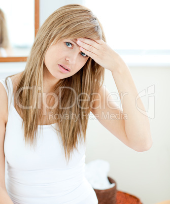 Depressed woman with a headache looking at the camera