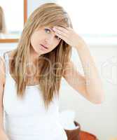 Depressed woman with a headache looking at the camera