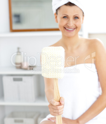 Merry woman holding a brush smiling at the camera