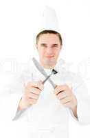 Confident male cook holding fork and knife smiling at the camera