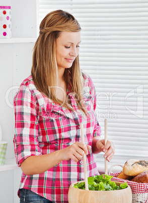 Concentrated young woman preparing a salad