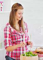 Concentrated young woman preparing a salad