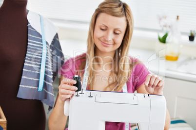Bright young woman using her sewing machine