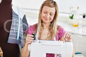 Bright young woman using her sewing machine