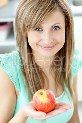 Portrait of a beautiful woman holding an apple looking at the ca