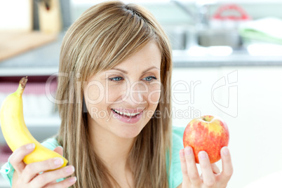 Jolly young woman holding an appke and a banana