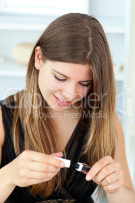 Portrait of beautiful young woman using mascara