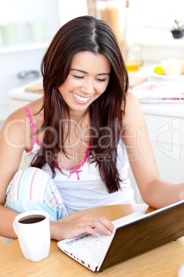 Positive asian woman using her laptop in the morning
