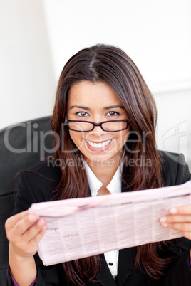 Charming asian businesswoman holiding a newspaper smiling at the