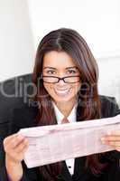 Charming asian businesswoman holiding a newspaper smiling at the