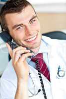 Portrait of an attractive doctor talking on phone smiling at the