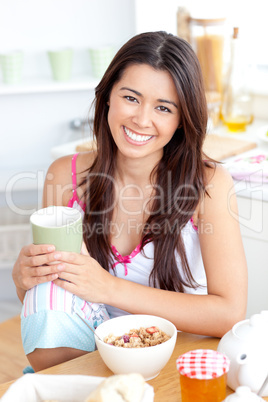 Beautiful asian woman having breakfast smiling at the camera
