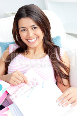 Happy asian woman with shopping bags smiling at the camera