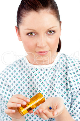 Dejected ill woman holding pills looking at the camera