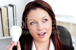 Surprised businesswoman holding a light bulb