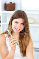 Delighted woman holding a toothbrush smiling at the camera