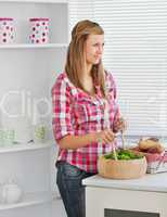 Attractive young woman preparing a salad