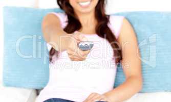 Close-up of an asian woman holding a remote sitting on a sofa