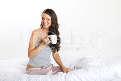 junge frau im bett mit tasse kaffee