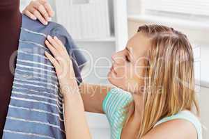 Concentrated young woman sewing clothes at home