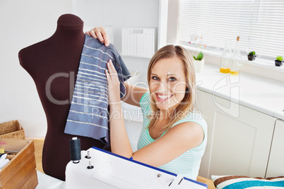 Merry woman sewing clothes at home