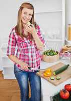 Charming woman cutting pepper and cucumber at home