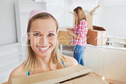 Two positive women carrying boxes at home