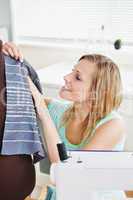 Radiant woman sewing clothes in the kitchen