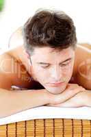 Caucasian relaxed young man lying on a massage table