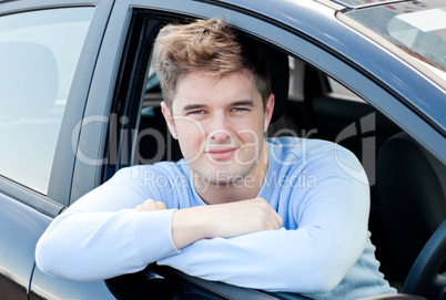 Positive young man sitting in his car