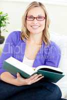 Portrait of an attractive woman with glasses reading a book