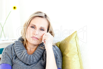 Portrait of a depressed woman lying on a sofa