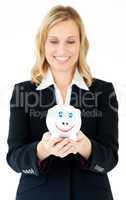 Charming businesswoman holding a piggy-bank