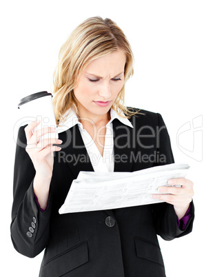 Attractive businesswoman reading a newspaper holding a coffee