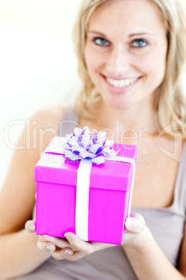 Charming woman holding a present in front of her