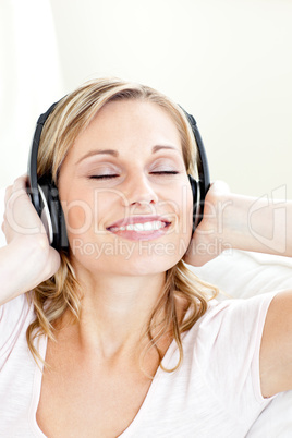 Radiant young woman listening to music wearing headphones