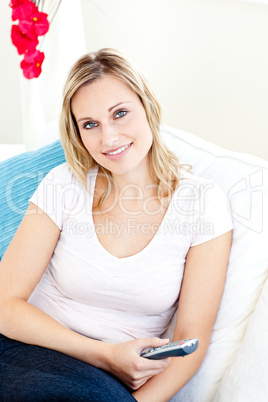 Smiling caucasian woman holding a remote