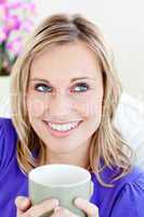 Portrait of a caucasian blond woman enjoying her coffee sitting