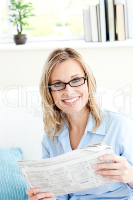 Positive businesswoman reading newspaper in the office