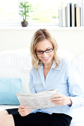 Glowing businesswoman reading newspaper in the office