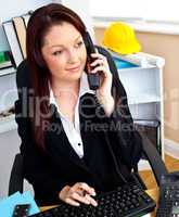 Confident businesswoman talking on phone using her computer