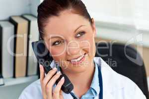 Attractive female doctor phoning in her office